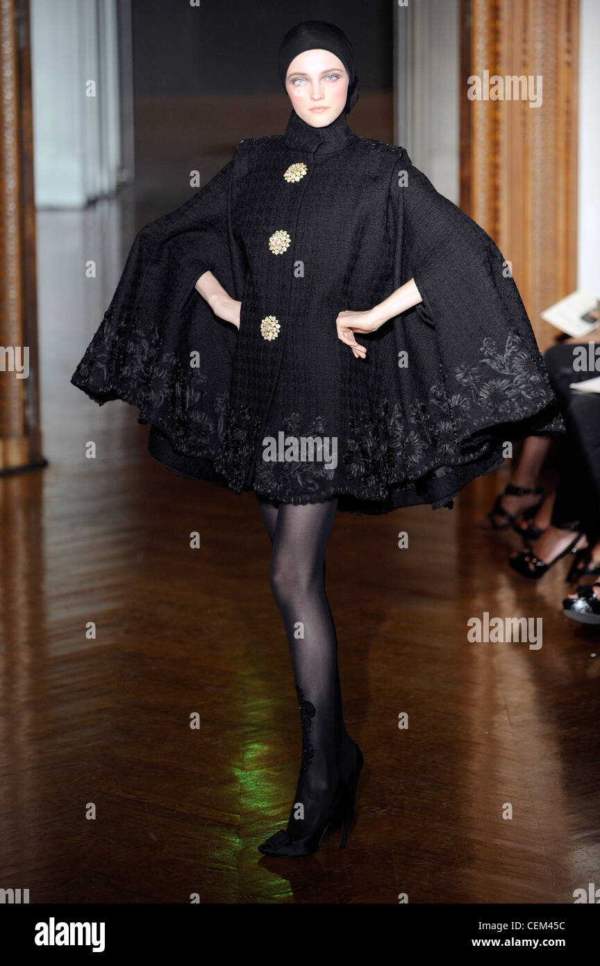 Christian Lacroix Paris Haute Couture Autumn Winter Model wearing a short  black cape coat oversized buttons and embroidery Stock Photo - Alamy