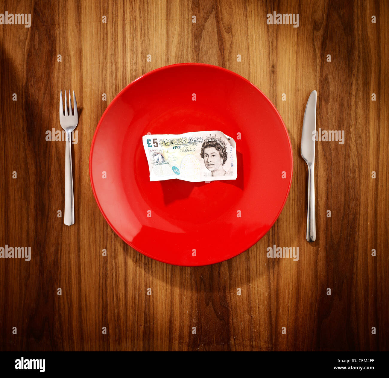 a five pound note on a dinner plate Stock Photo Alamy