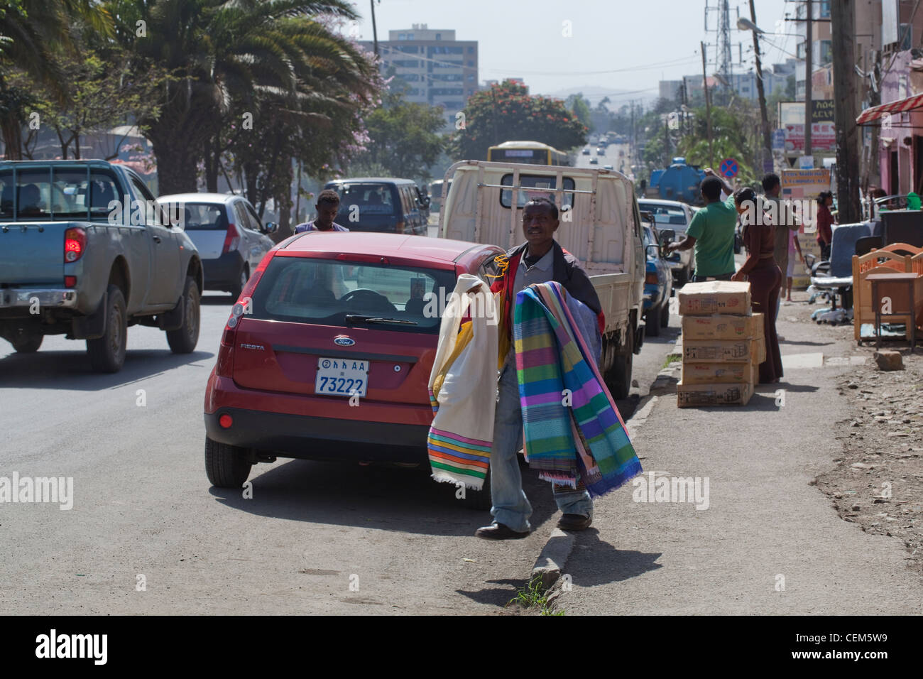 Addis Ababa, Ethiopia. Street trader of woven fabrics. Pedestrians and traffic. Stock Photo