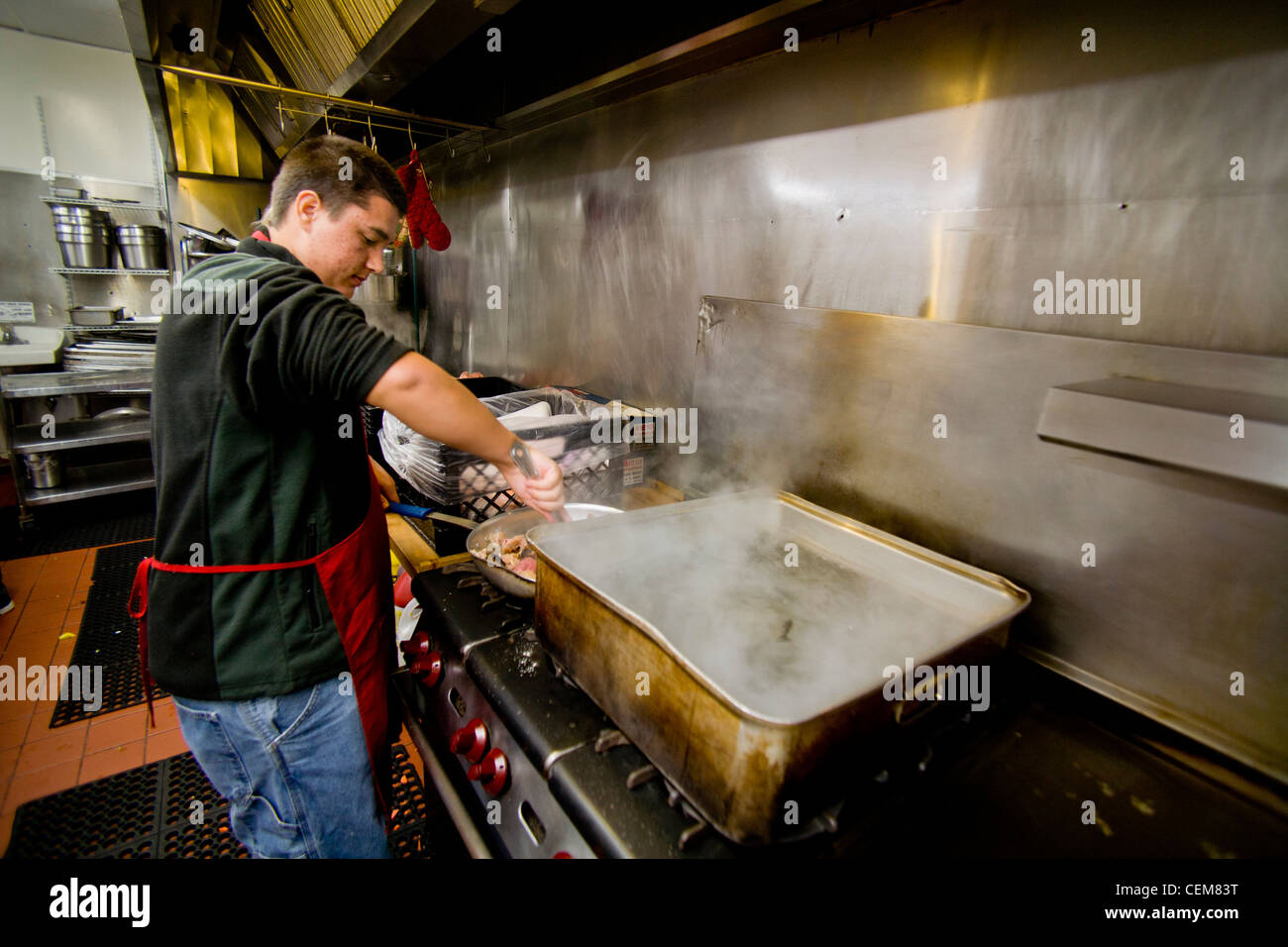 Middle class charitable volunteers pitch in at a Costa Mesa, CA, soup kitchen to feed the homeless. Stock Photo
