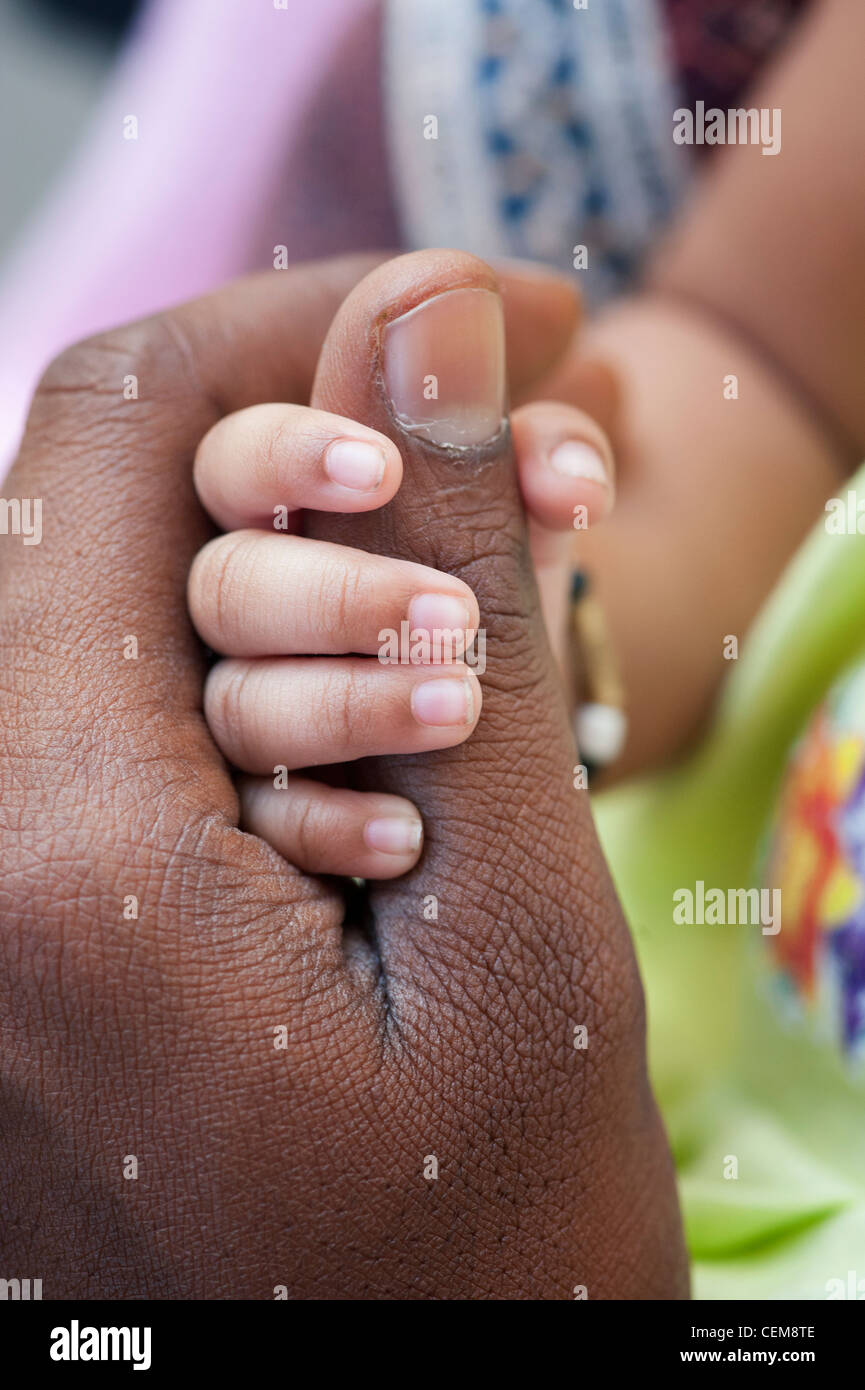 Indian mans hand holding his new born babies hand. Andhra Pradesh, India Stock Photo
