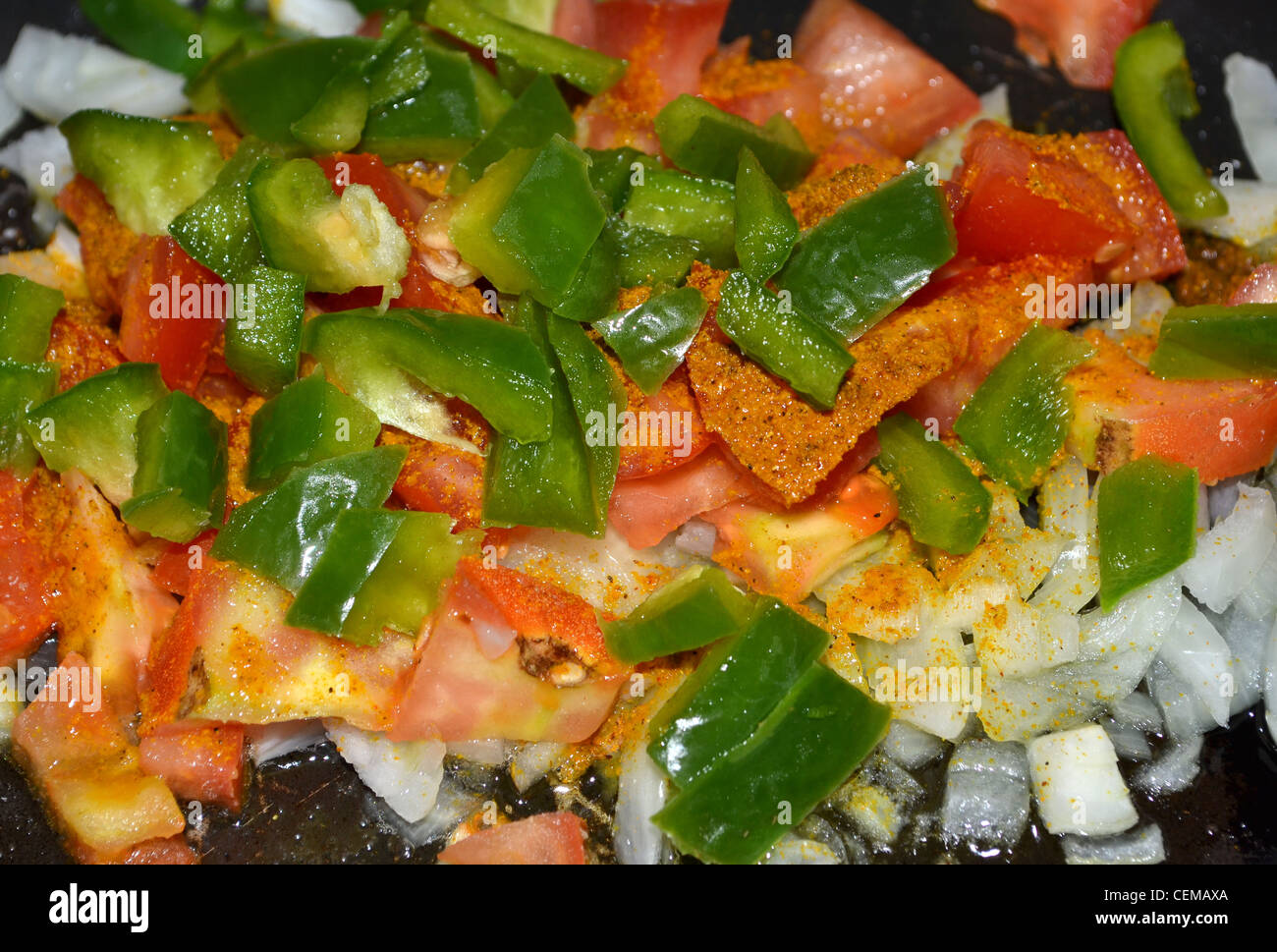 curry ingredients capsicum tomato onion and curry powder Stock Photo