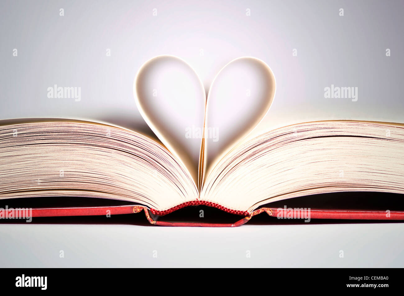 book with heart shaped pages over gradient background Stock Photo
