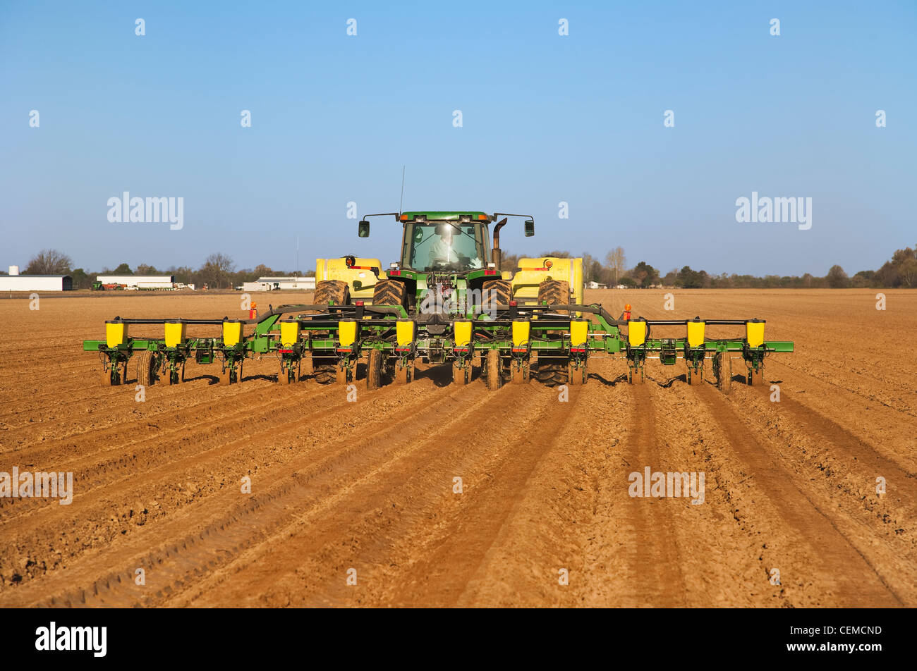 Agriculture - A John Deere tractor and 12-row planter plant grain corn in a conventionally tilled field / Arkansas, USA. Stock Photo