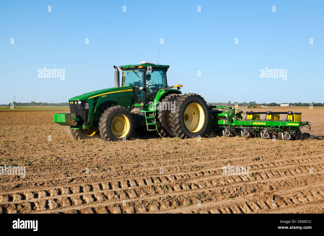 Agriculture - A John Deere tractor and 12-row MaxEmerge planter plant cotton on a bedded field in mid Spring / Arkansas, USA. Stock Photo
