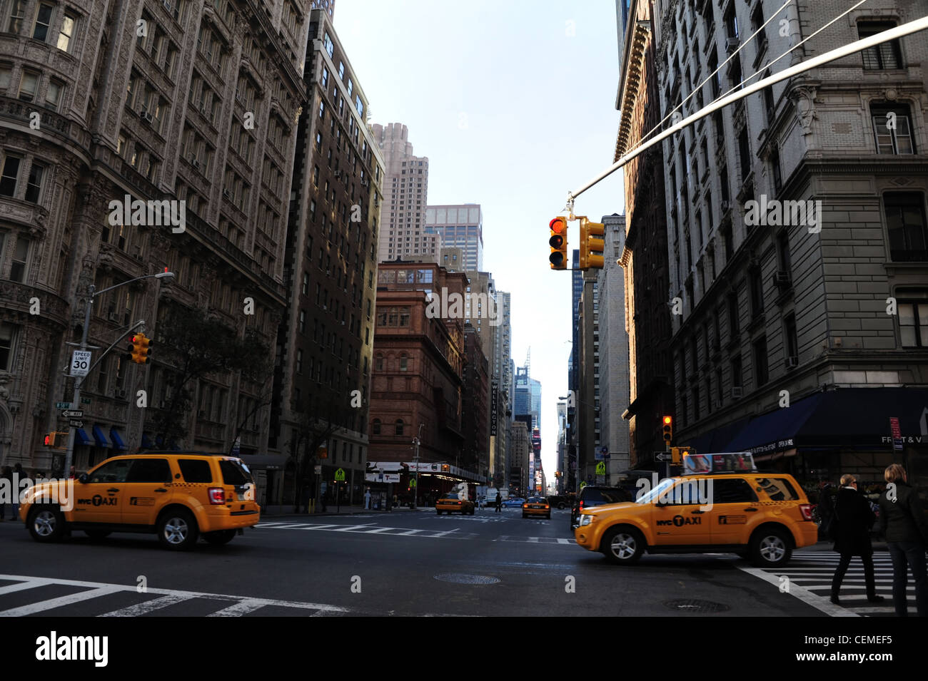 Blue sky sun shade view, looking south towards Times Square, yellow taxis crossing 7th Avenue at West 58th Street, New York Stock Photo