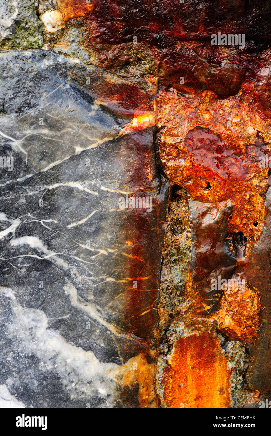 Rust stained rocks that are part of the sea wall at Dawlish in Devon