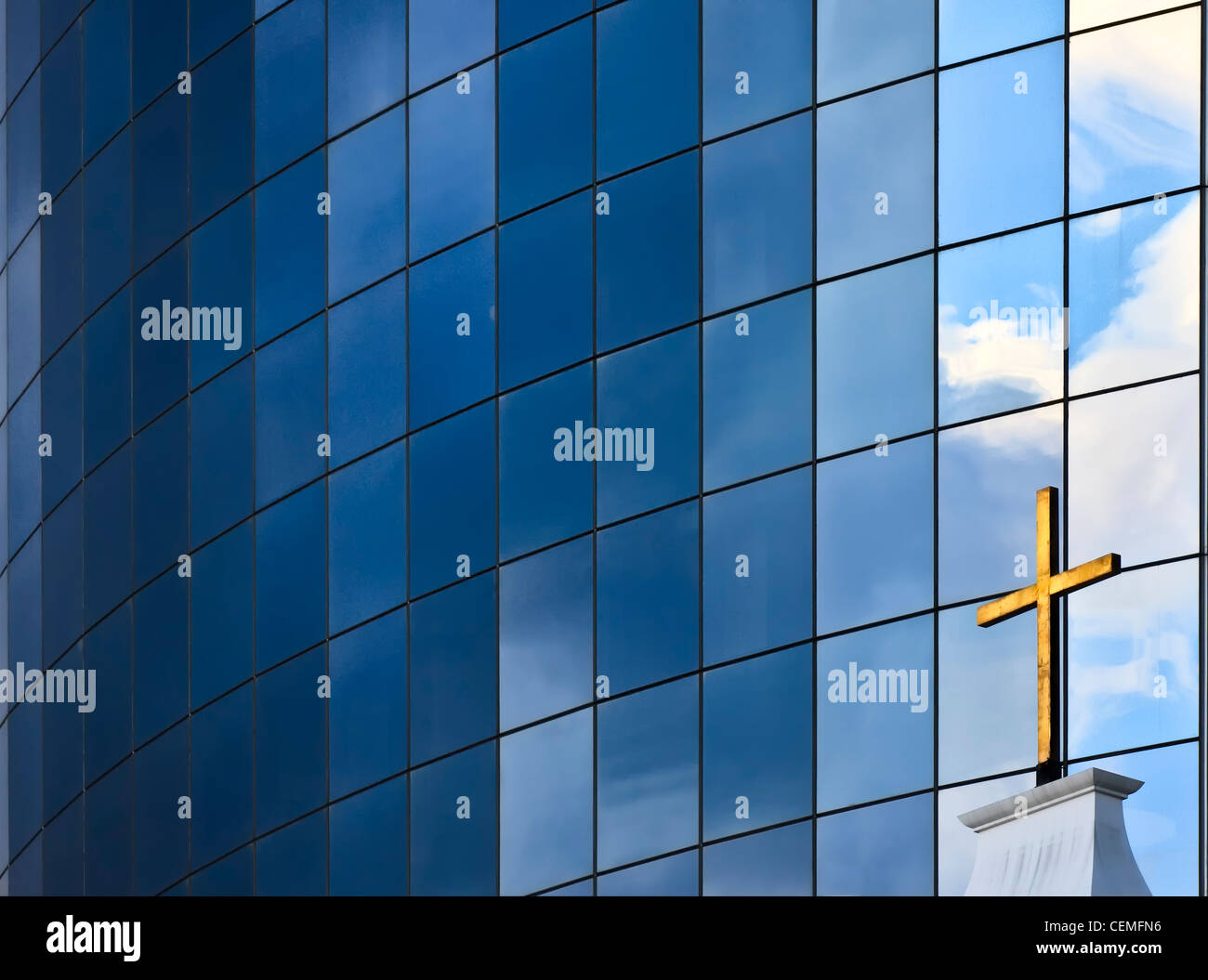 A golden Christian Cross in front of a modern glass building in New York City, USA Stock Photo