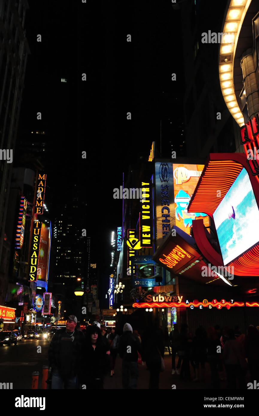 Night neon portrait, to Madame Tussauds & New Victory Theatre, sidewalk people,  cars, West 42nd Street at 7th Avenue, New York Stock Photo