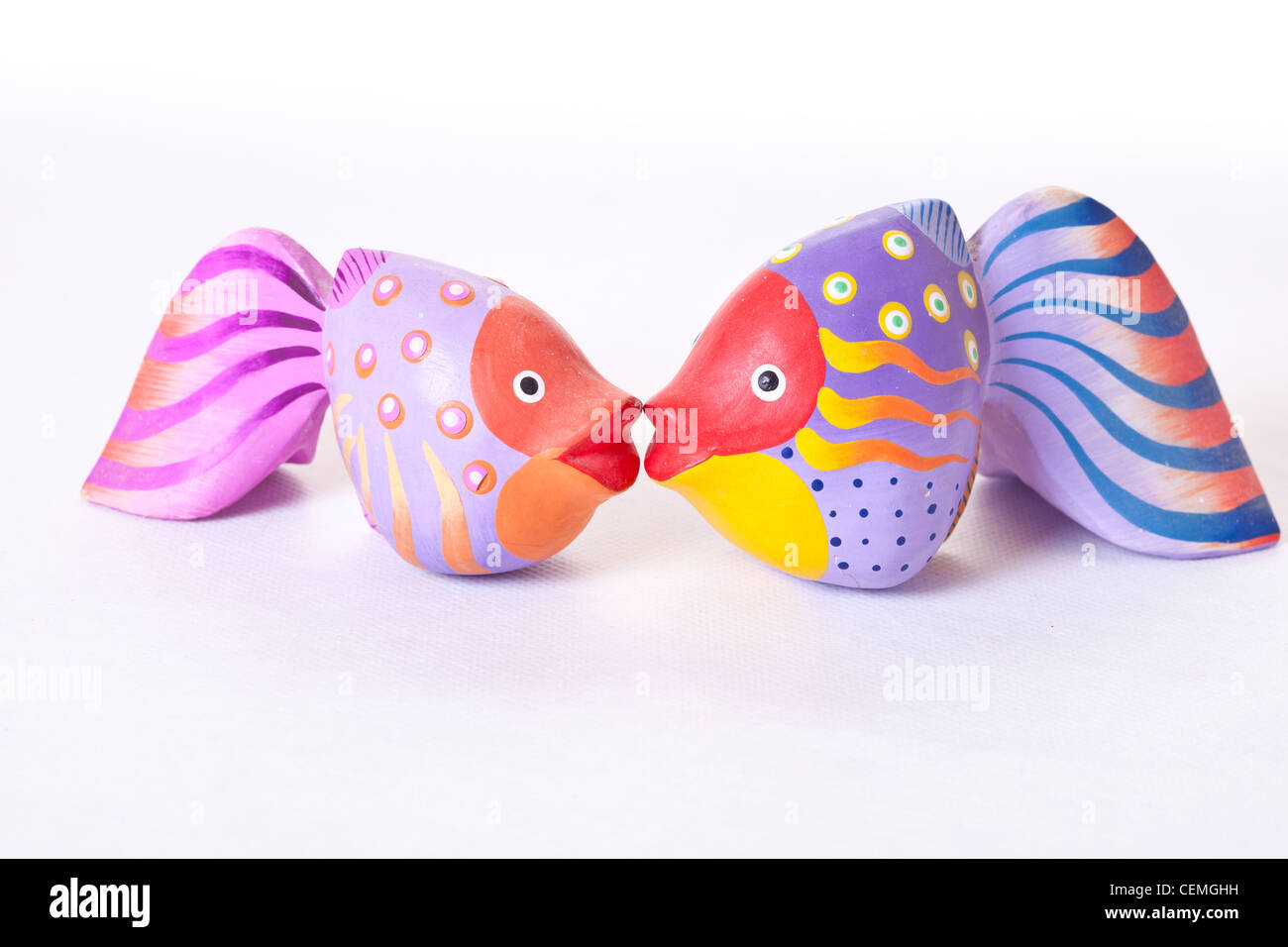 wooden brightly coloured fish ornaments, kissing fish pouting fish, purple fish,pink fish,lilac fish,decorative fish,ornamental Stock Photo