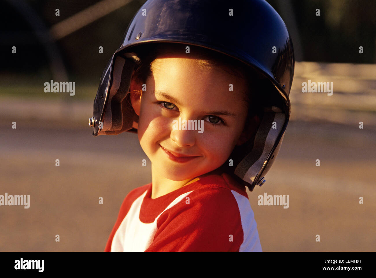Young girl Little League Baseball player sunset light portrait Stock