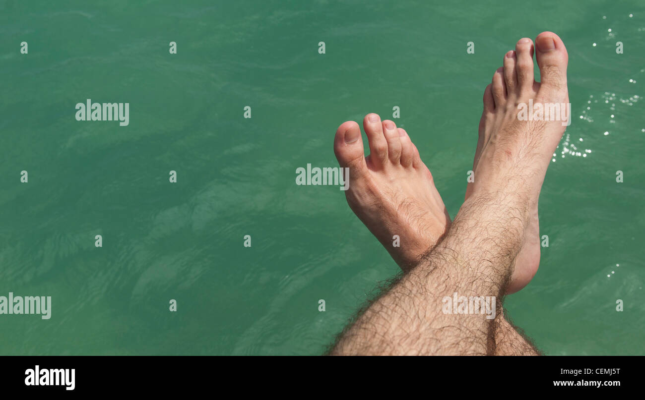relaxing feet on lake during a hot sunny day (summer vacations concept) Stock Photo