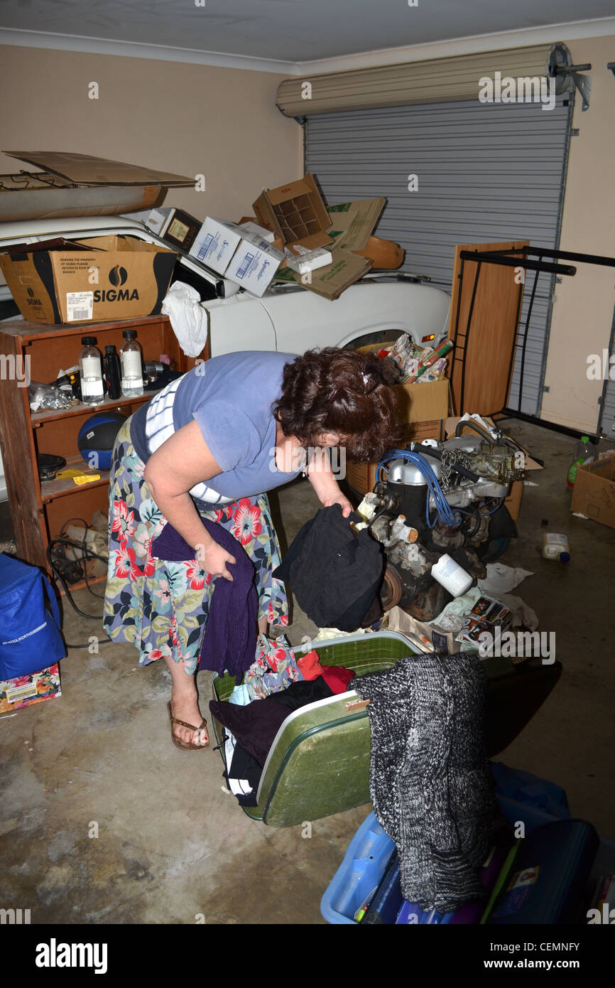 Woman sorting through a hoarders garage Stock Photo Alamy