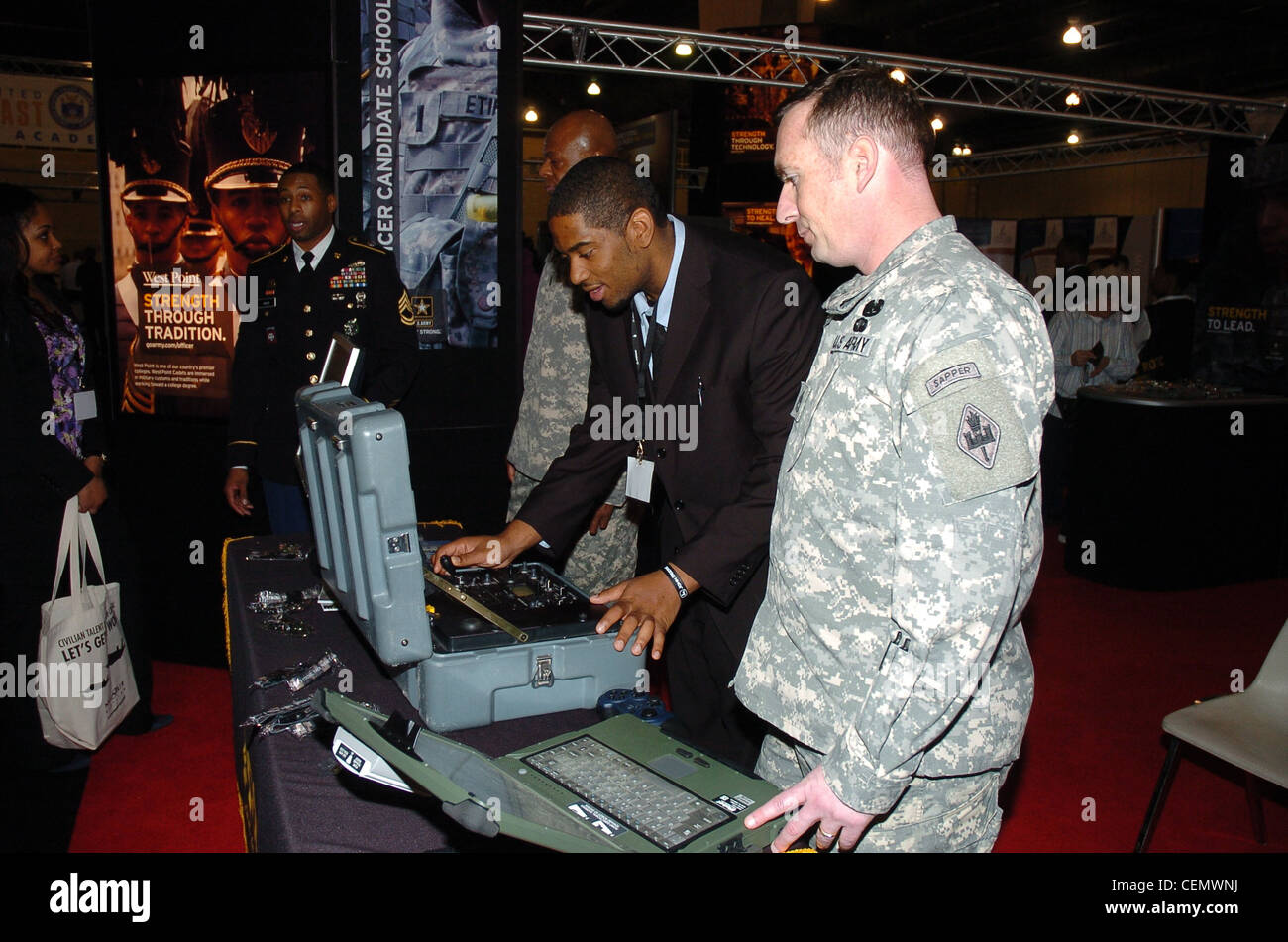 Sgt. 1st Class Todd Moyer, U.S. Army Engineer, Fort Leonard Wood, Mo., works with a student at the US Army robotic display during the BEYA high tech Expo in Philadelphia, Feb. 18, 2012. Stock Photo