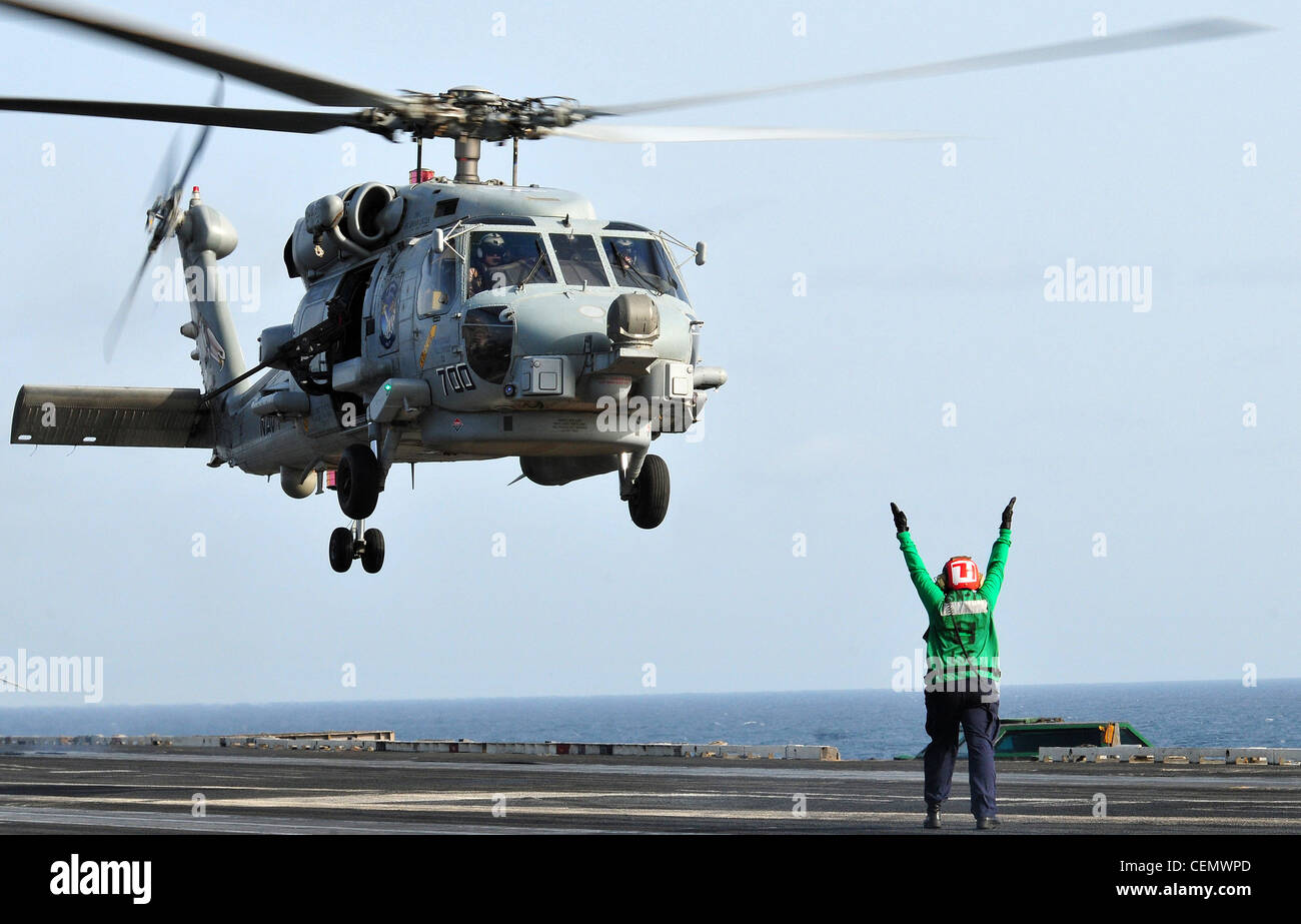 Airman Kana D. Boudreaux signals to the pilot of an MH-60R Sea Hawk ...