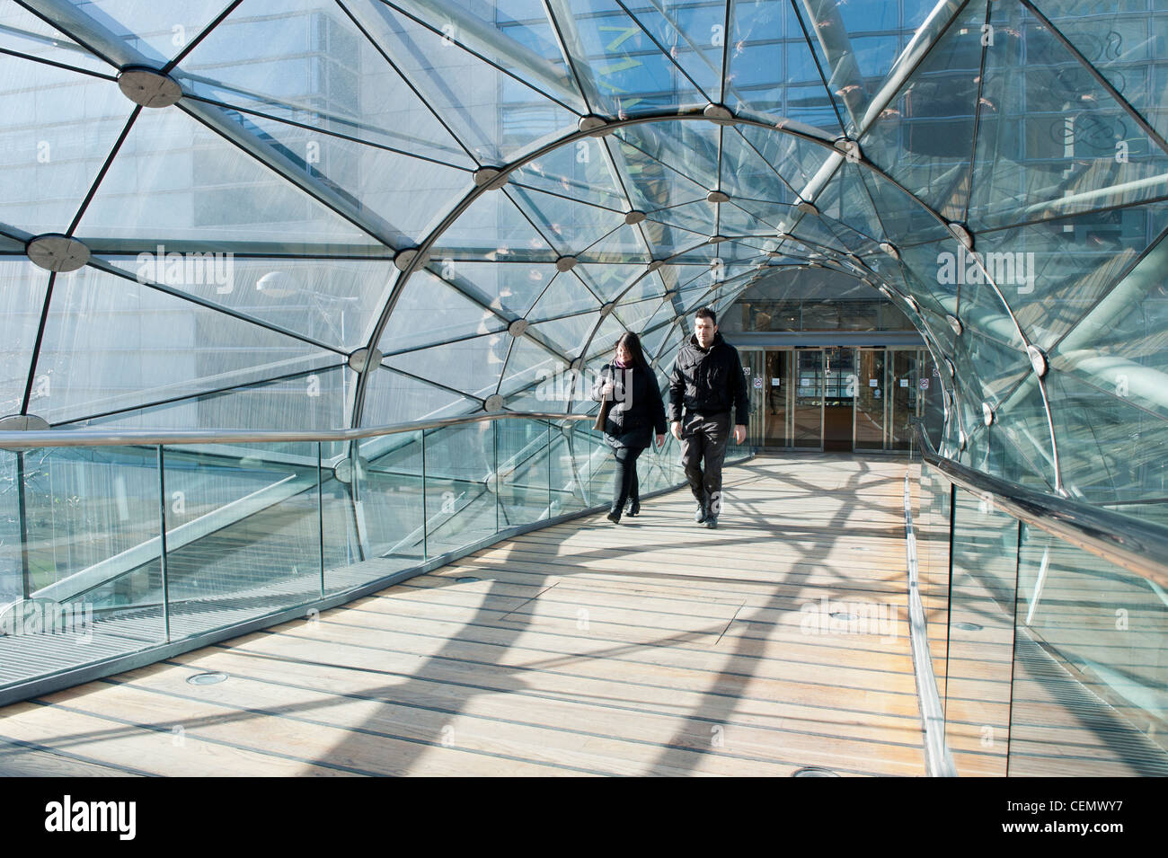 Shoppers walk through glass tunnel connecting Manchester Arndale centre to Marks and Spencer and Selfridges. Stock Photo