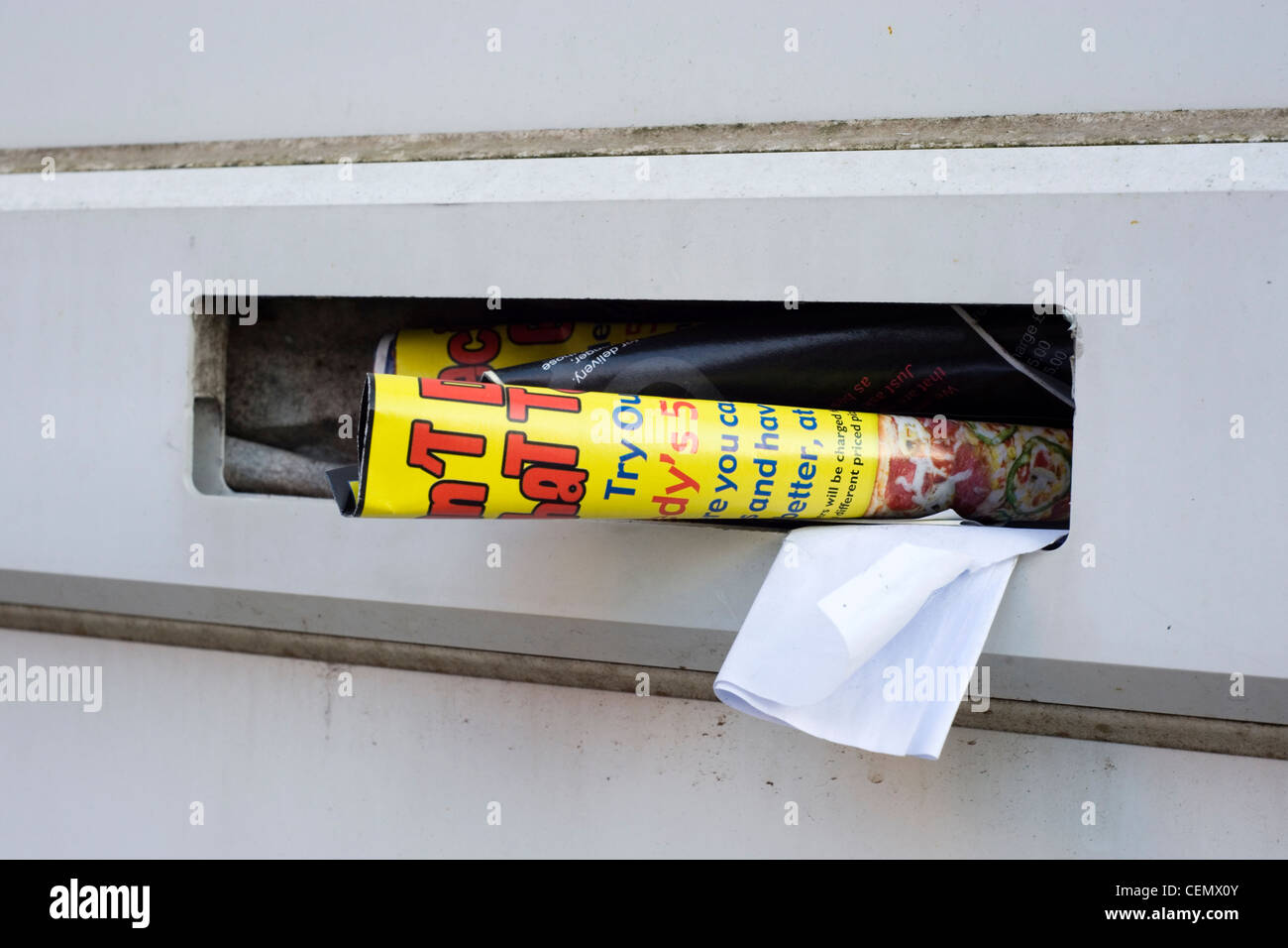 junk mail stuffed into a letter box Stock Photo