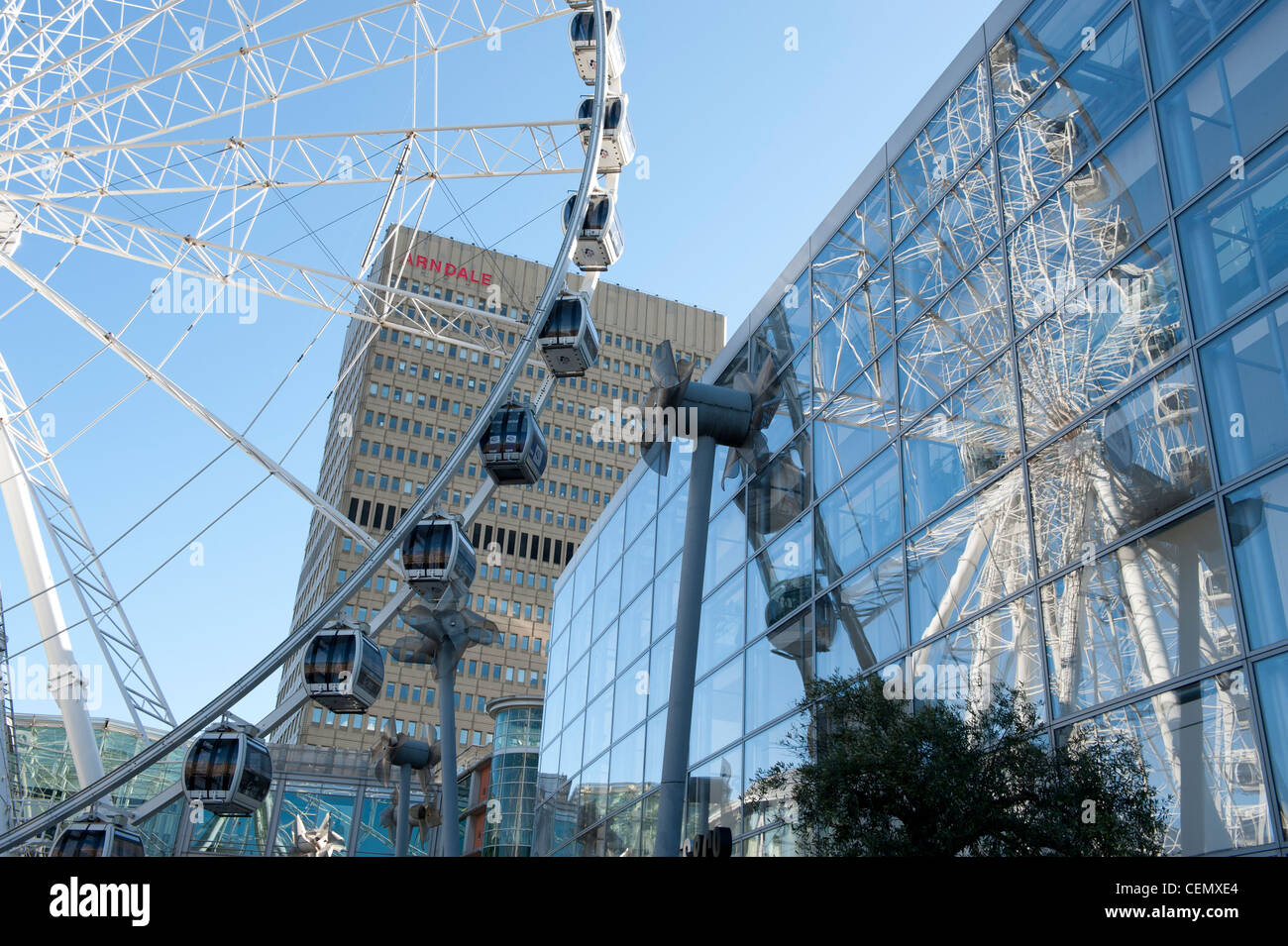 Wheel of Manchester reflecting on glass exterior of Selfridges in Exchange Sqaure,  Manchester city centre. Stock Photo