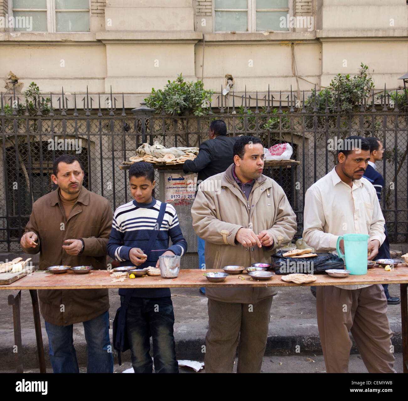 men and boy eating food at roadside stall, Cairo, Egypt Stock Photo