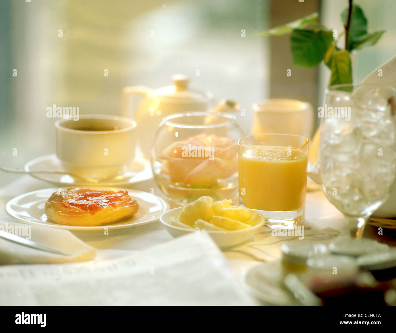 Continental Breakfast, room service at a hotel, spa, pastry with orange juice and tea, empty glass with ice and rose in bowl Stock Photo
