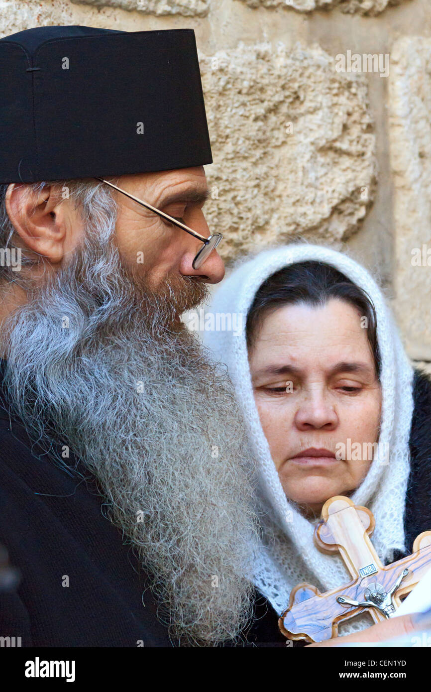 Greek Orthodox priest leads faithful people in prayer at the Church of