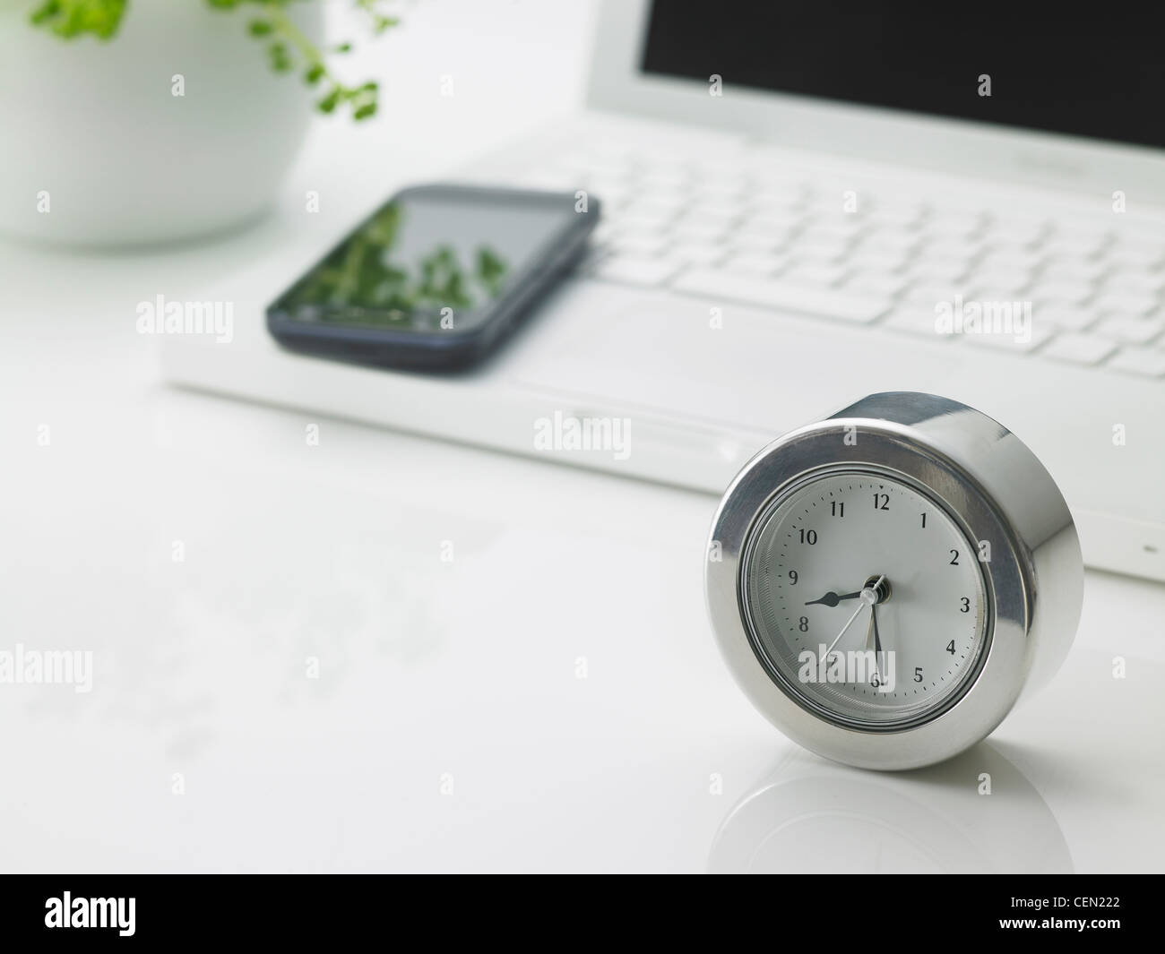 Laptop, smart phone and clock Stock Photo