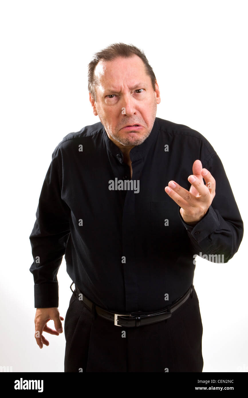 Grumpy old man dressed in black stretches out his hand with a look of contempt and anger. Stock Photo