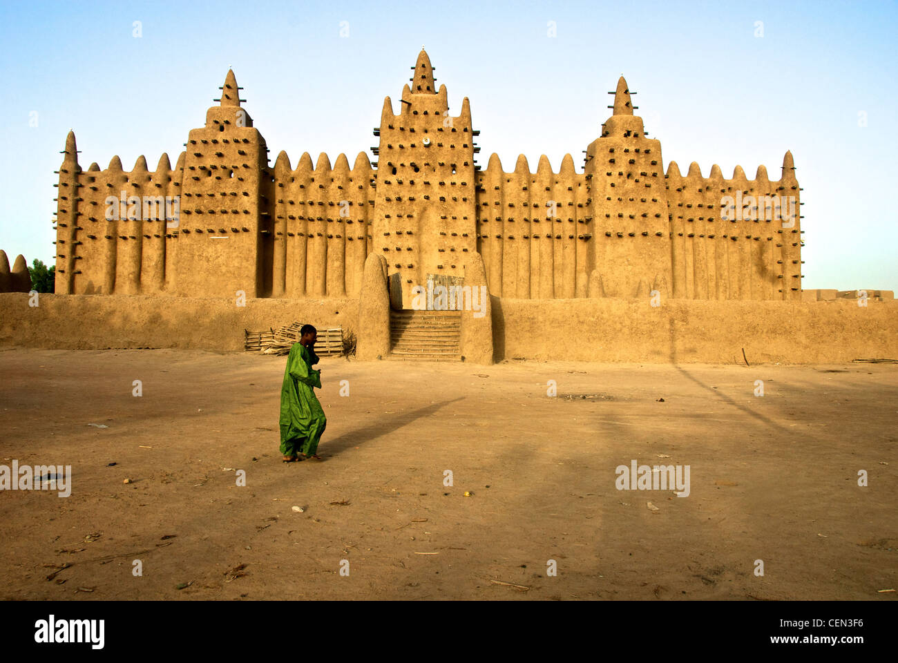 A man walks past the Great Mosque of Djenne in Djenne, Mali Stock Photo