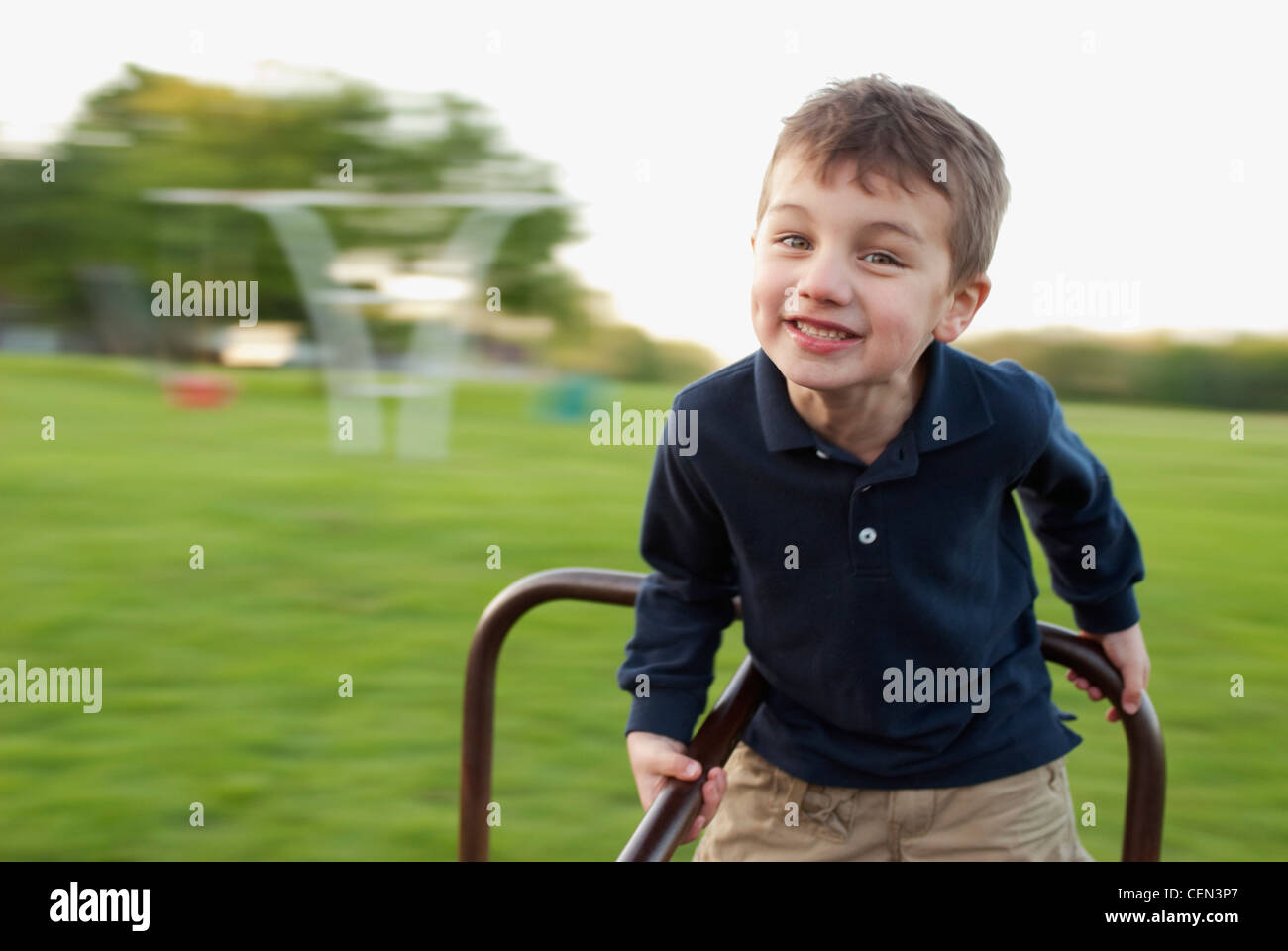 Five Year Old Boy Playing On A MerryGoRound Stock Photo Alamy