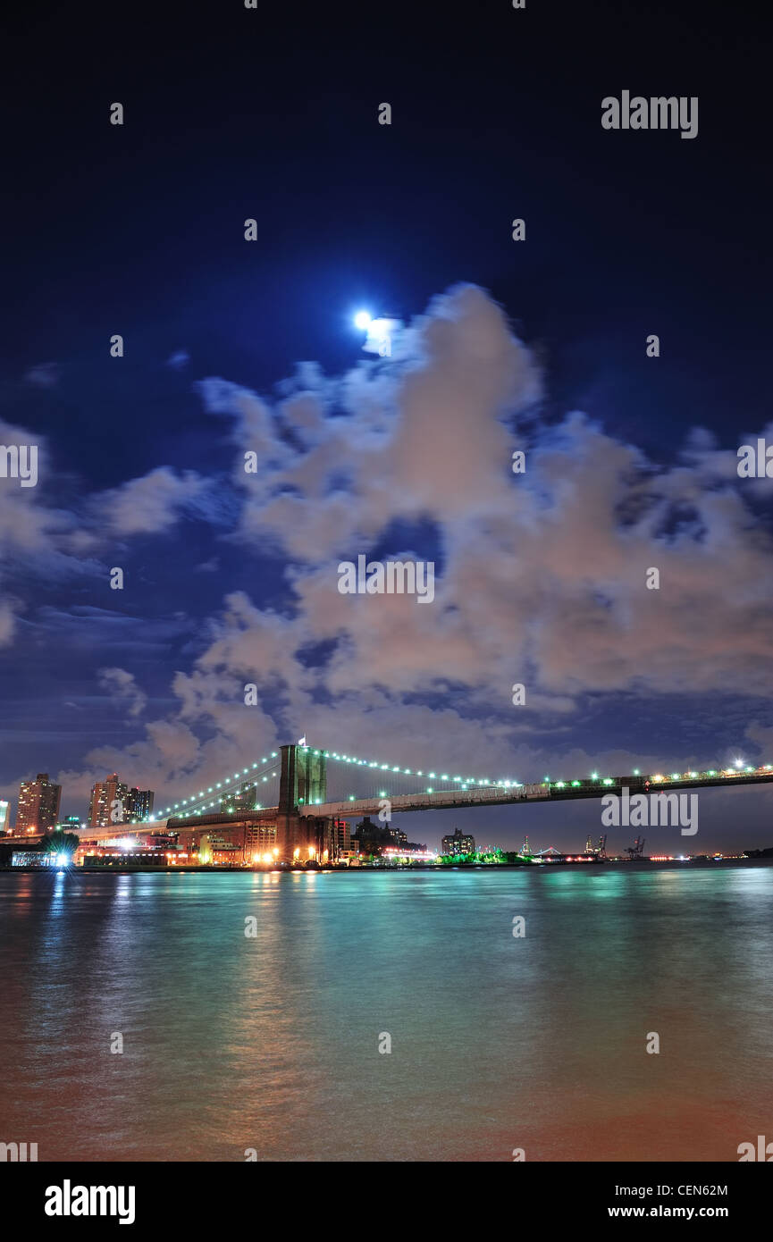 Brooklyn Bridge over East River at night with moon in New York City ...
