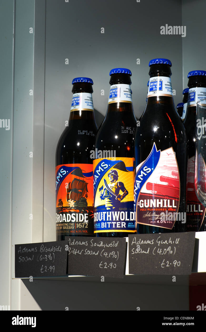 Close up of four bottles of beer for sale on a shelf, showing price labels. Stock Photo