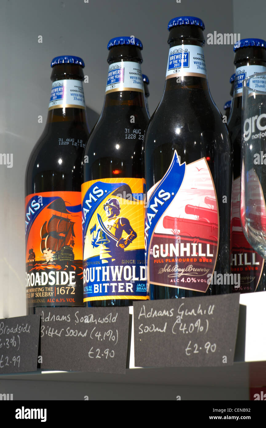Close up of three bottles of beer for sale on a shelf, showing price labels. Stock Photo