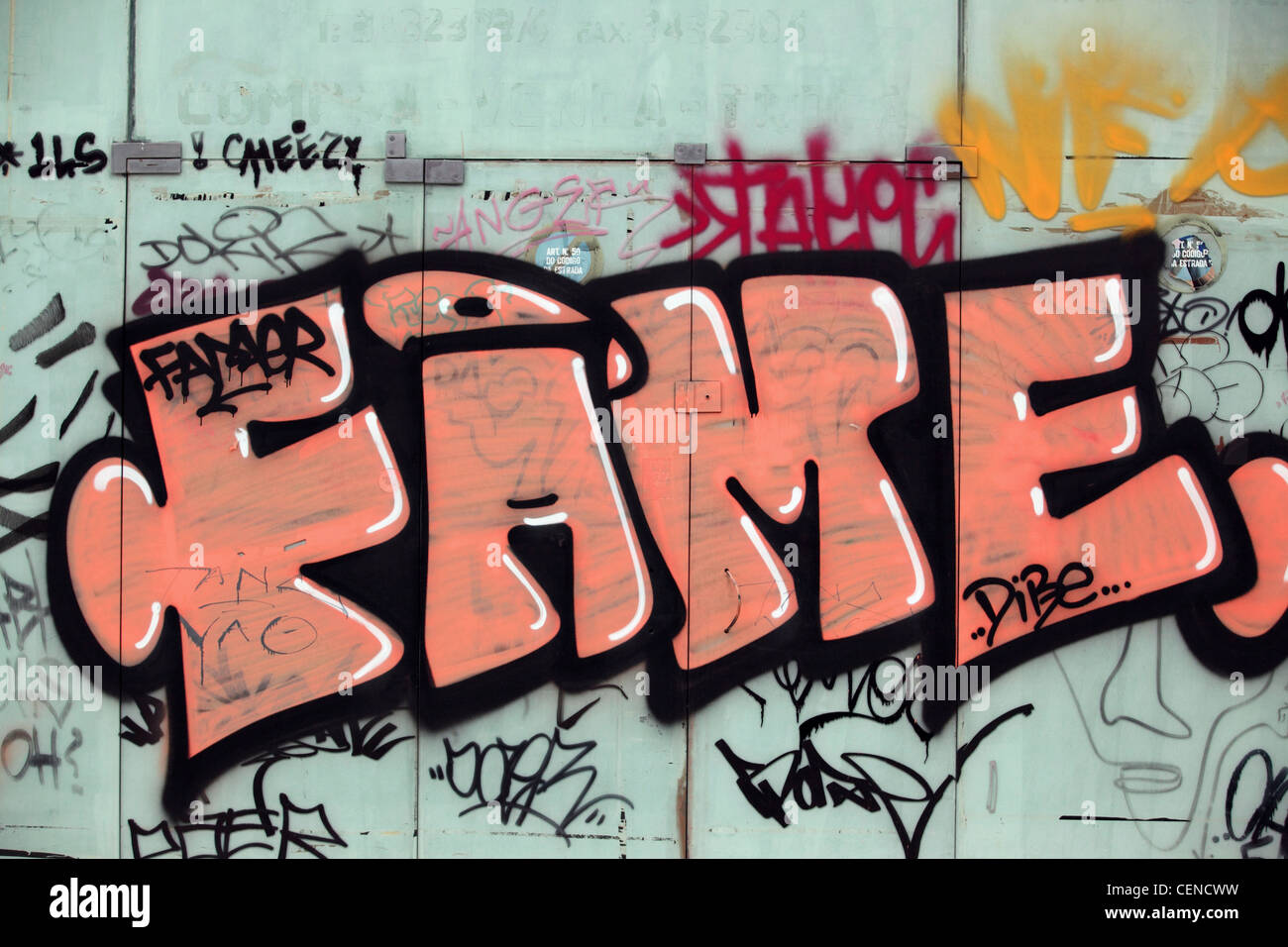 Orange graffiti stylized writing 'FAME' on closed shop front, Lisbon, Lisboa, Prtugal, Europe Stock Photo