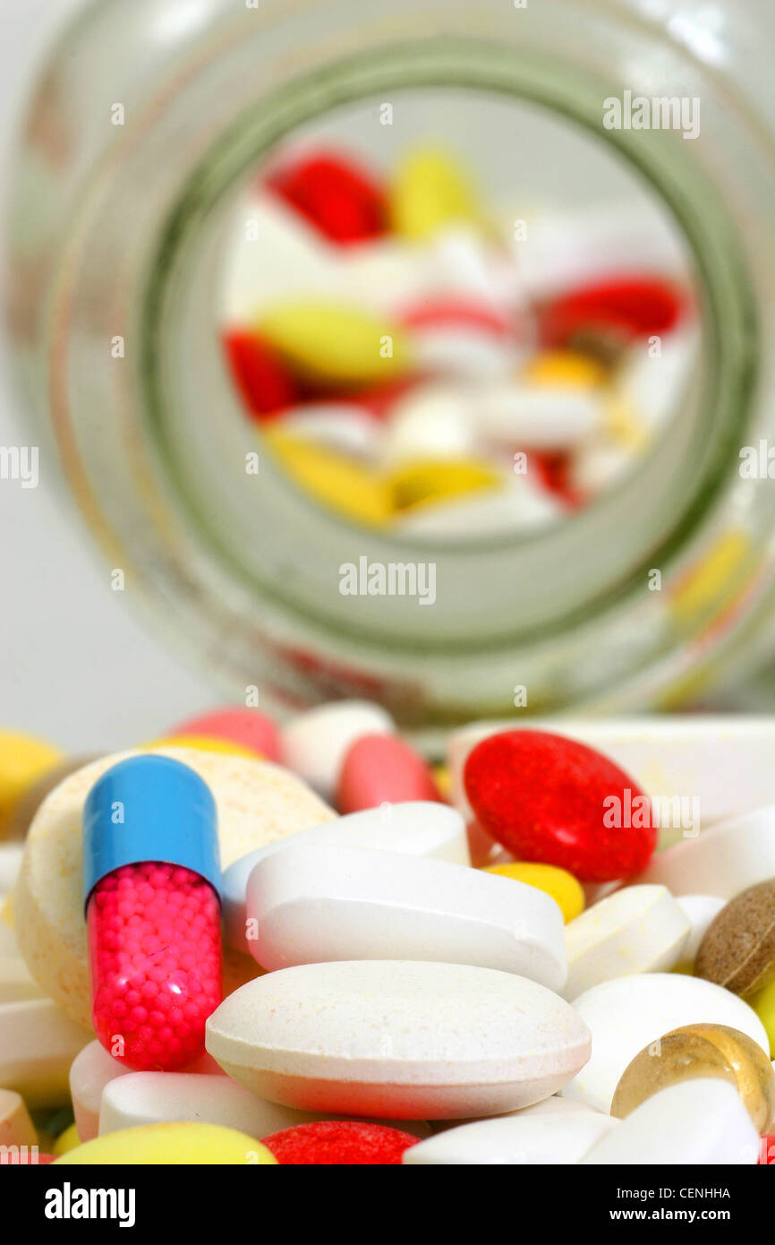 A pile of various tablets, capsules and liquid capsules including round
