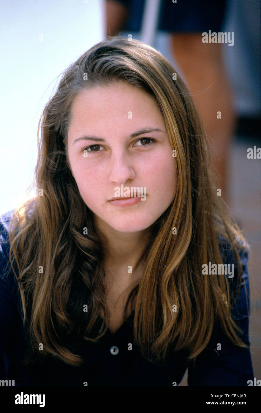 Female With Long Brunette Hair In Side Parting Wearing Dark Blue