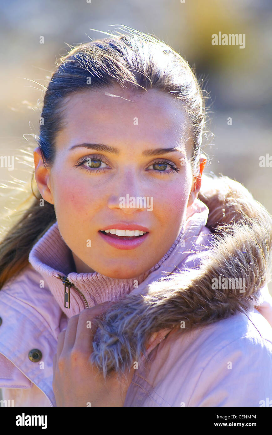 Female wearing a pink hooded jacket fur trim, pink lipstick, rosy