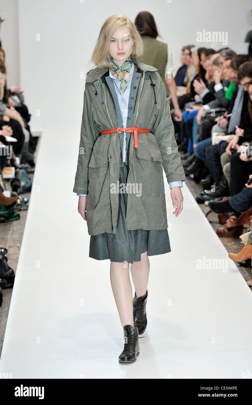 Grey coat, orange belt, patterned scarf, grey knee length a line skirt, black brogues Stock Photo