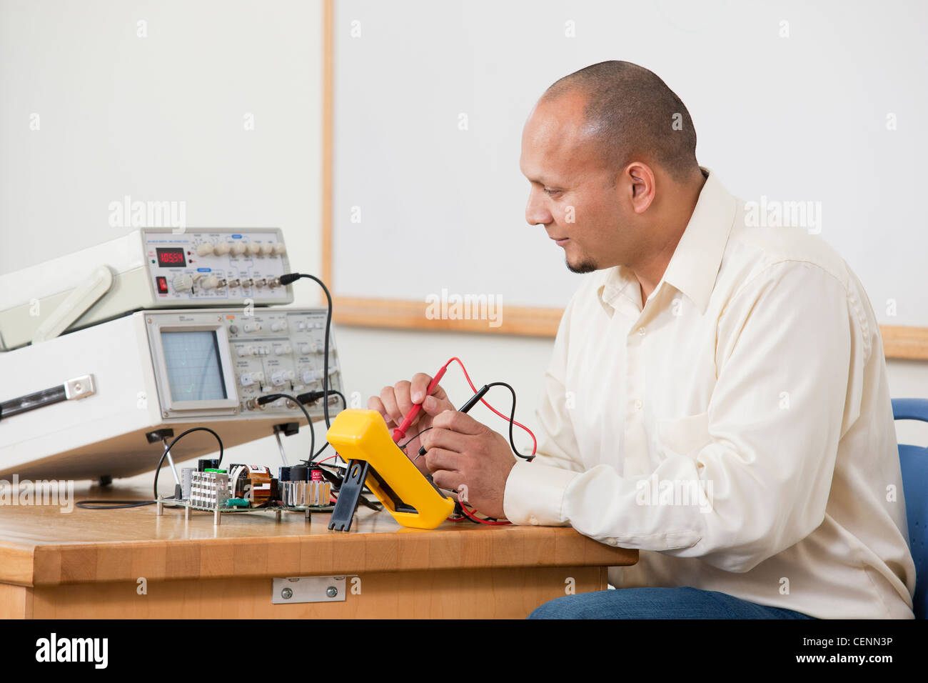 Hispanic engineering using multimeter probes to measure circuit