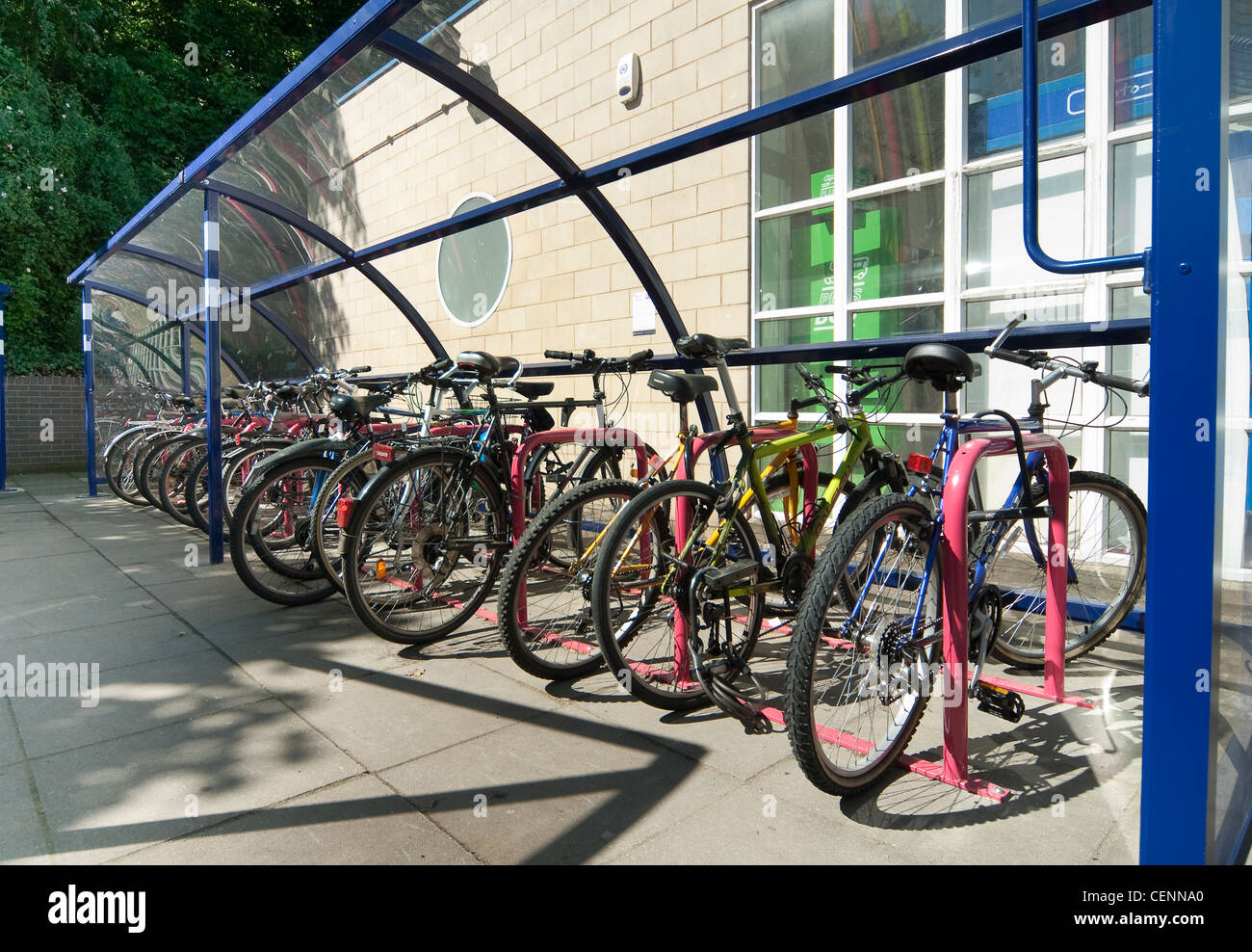 Bicycles securely parked in a bicycle shed outside a railway station in England. Stock Photo