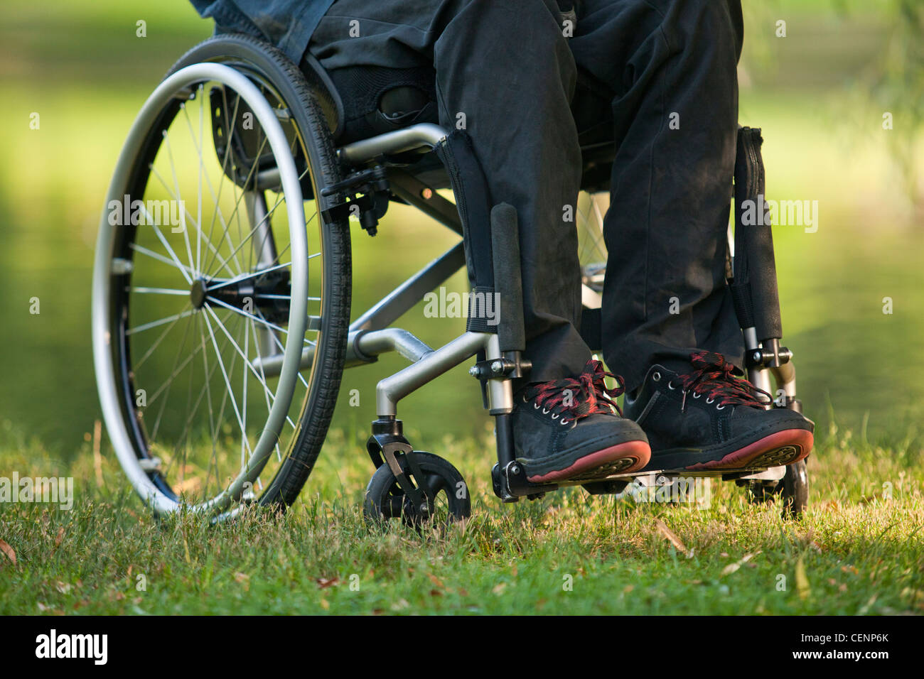 Low section view of a man in wheelchair with spinal cord injury in a park Stock Photo