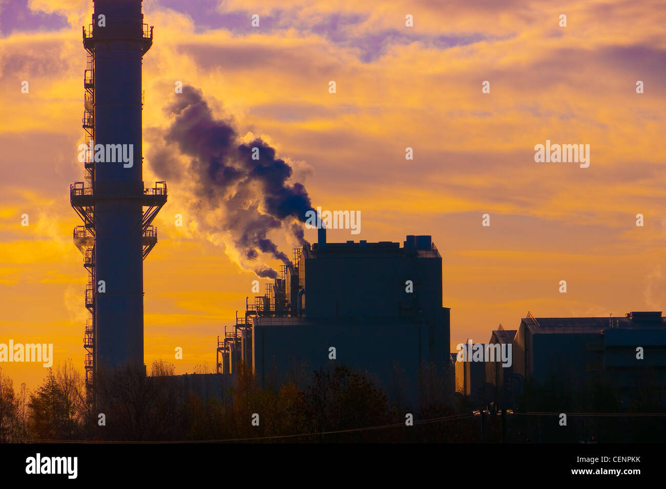 Dramatic sunset over gas power station steam rising into atmosphere Stock Photo