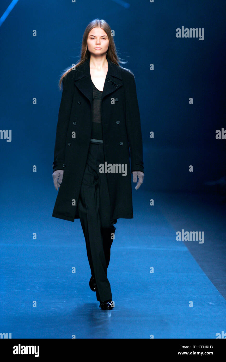 Costume National Milan Fashion Week Autumn Winter Model wearing narrow leg black trousers, sheer knit V neck black top, three Stock Photo