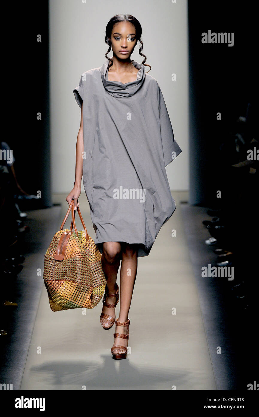 Bottega Veneta Milan Ready to Wear Spring Summer wearing plain grey poncho  dress, accessorized cut away holdall and strappy Stock Photo - Alamy