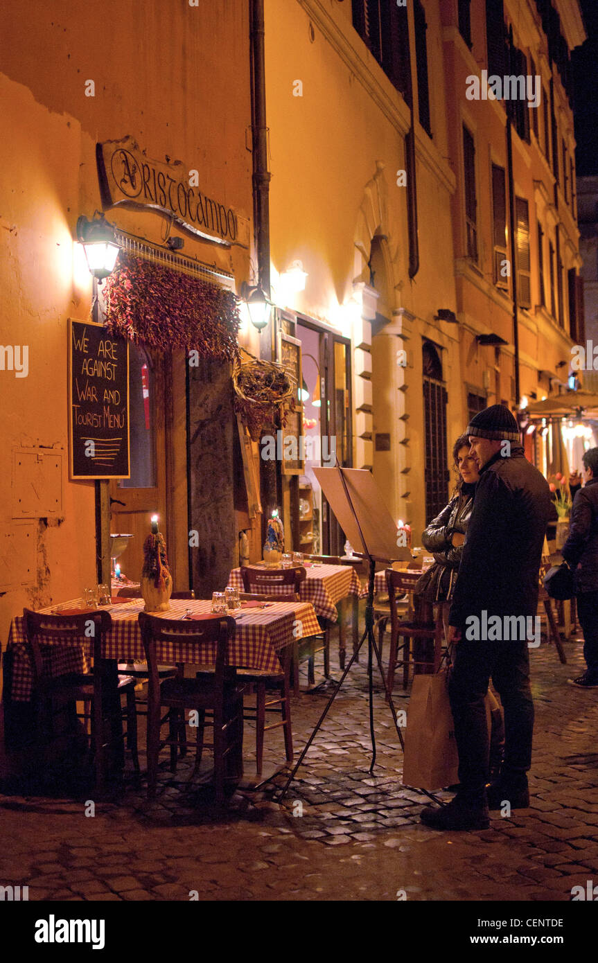Looking at the menu outside one of the restaurants in the Trastevere district of Rome in early spring. Stock Photo
