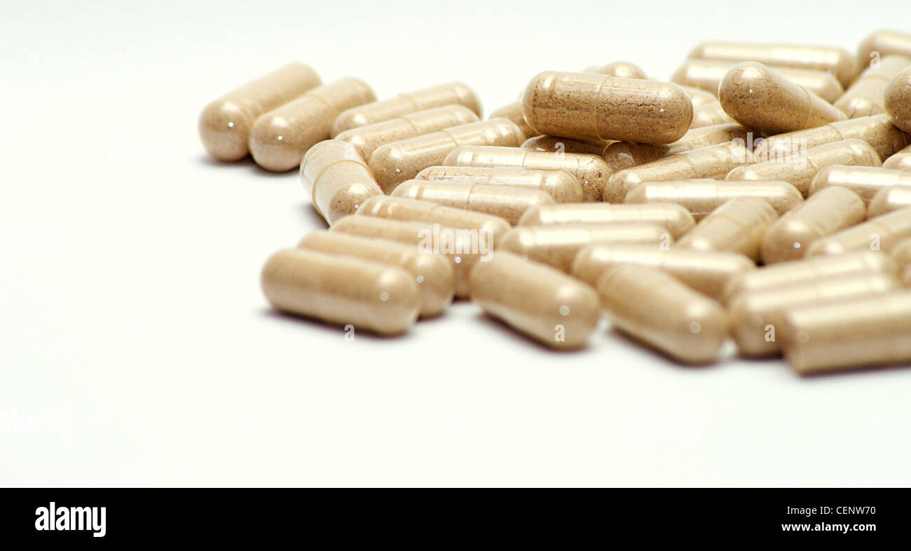 Closeup image of brown pills - roughage on the white background. Stock Photo