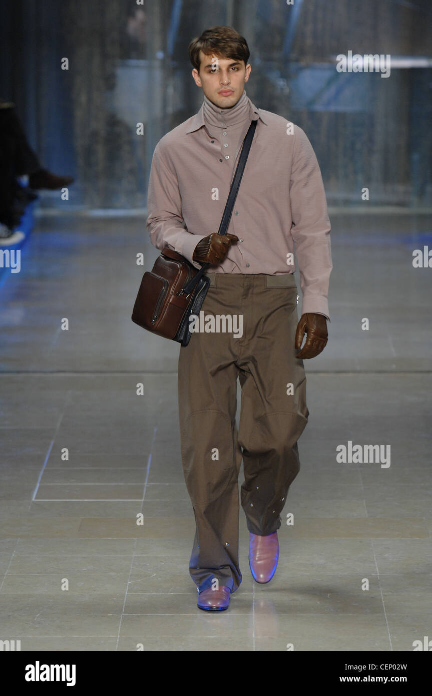 Long sleeved skirt over polo neck, baggy trousers, brown leather shoulder  bag and leather gloves, with reflective shoes Stock Photo - Alamy