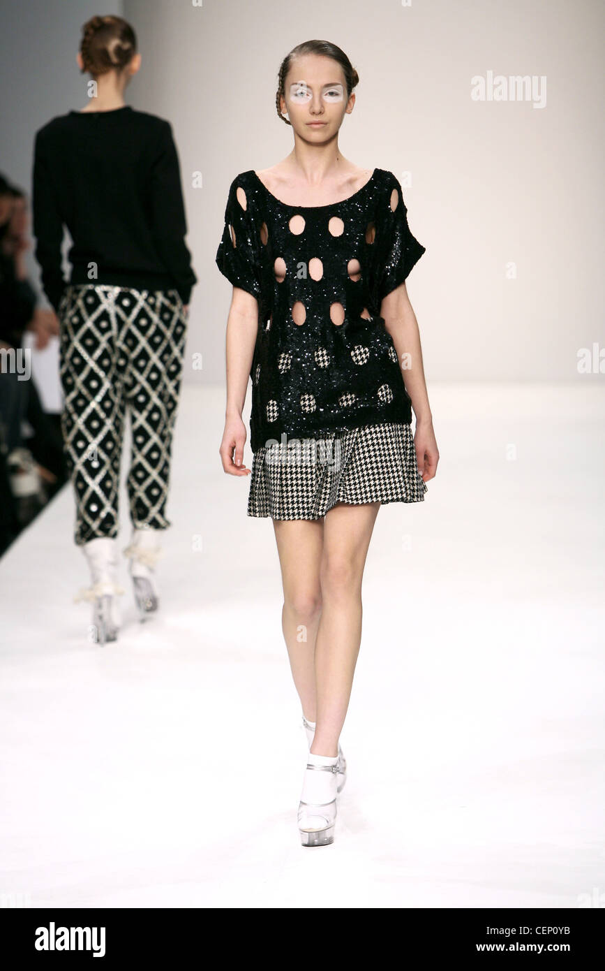 Ashish London Ready to Wear Autumn Winter Black and white check skirt,  black sequinned top holes, clear shoes over white socks Stock Photo - Alamy