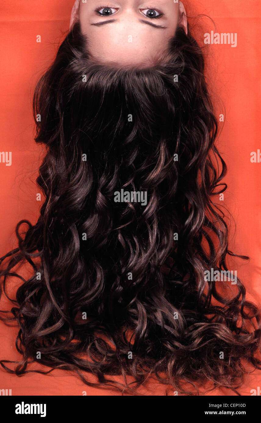 Female upside down with long curly brunette hair hanging down Stock Photo -  Alamy