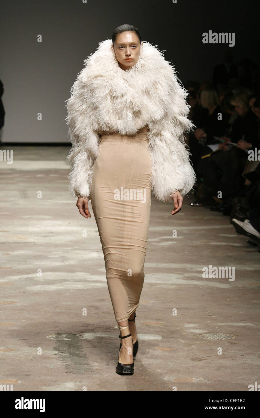 Beige skin tight stretchy dress, oversized cream furry cropped jacket Stock Photo