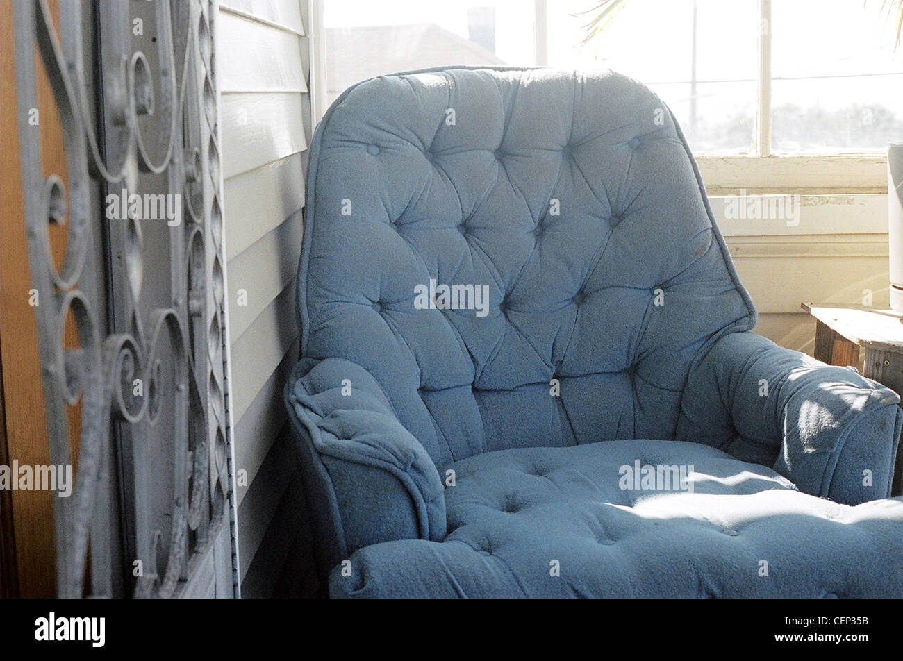 A close up of a blue button tufted upholstered armchair Stock Photo